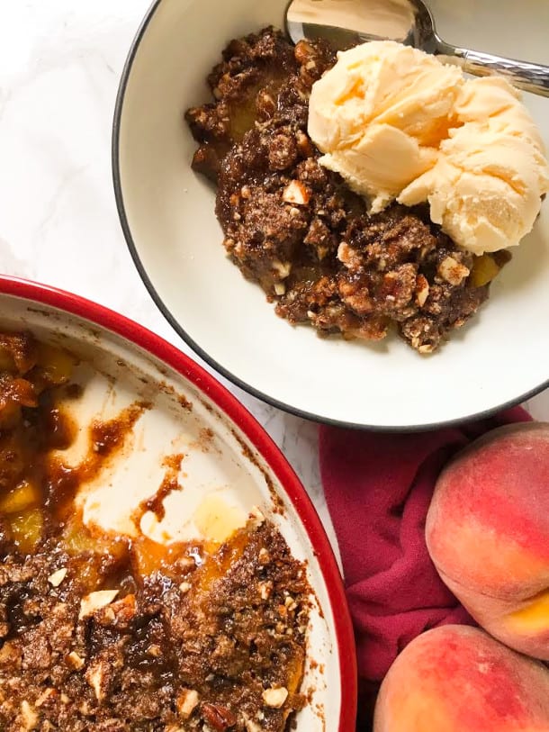 Peach Crisp in a pan and bowl with ice cream on top