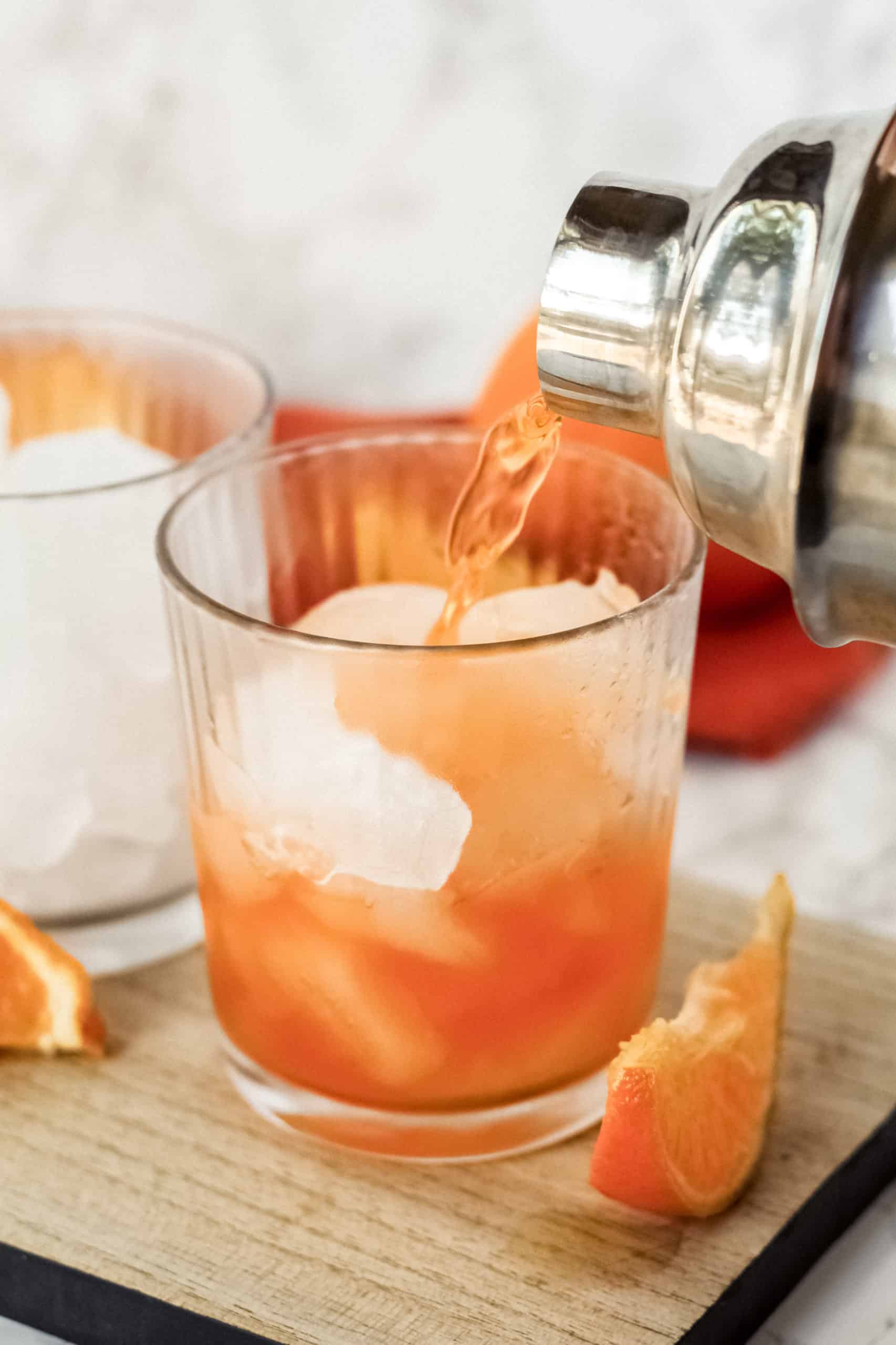 Pouring an orange thunder into a glass with ice