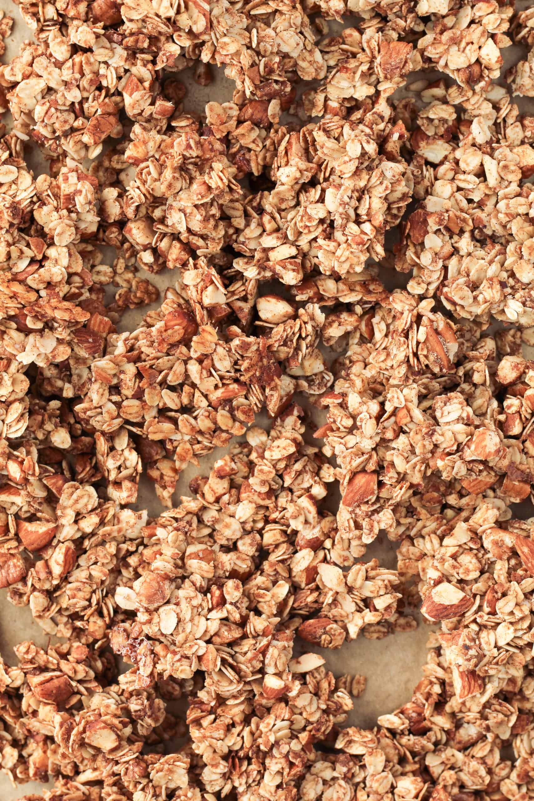 Chunks of granola spread out on a baking sheet.