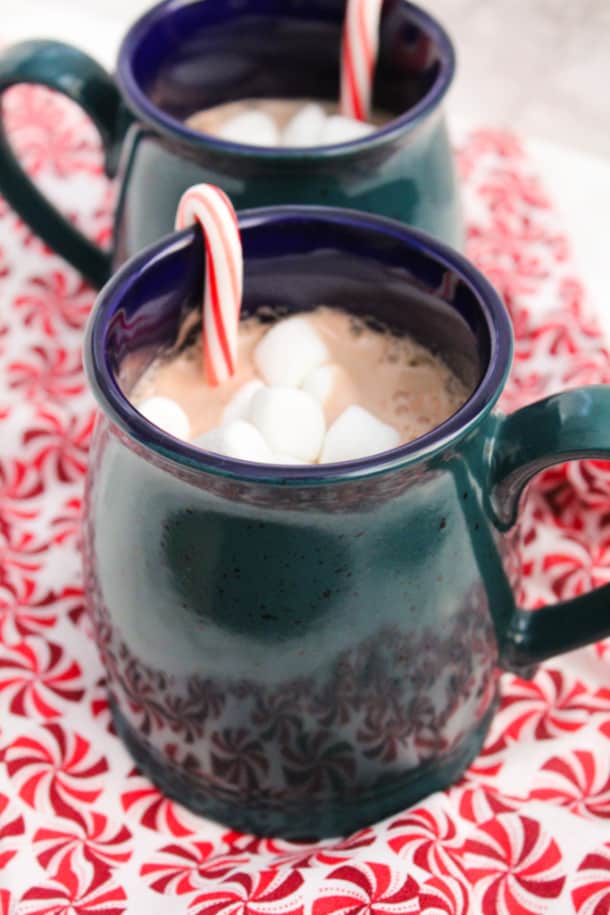 Peppermint Hot Cocoa in a mug with mini marshmallows and a mini candy cane sticking out