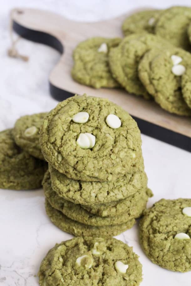 a stack of Matcha Oatmeal White Chocolate Chip Cookies with more cookies around it