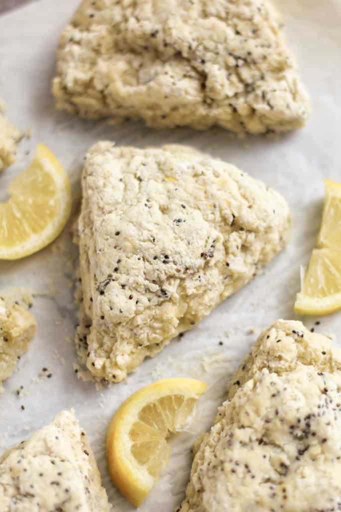 Lemon Chia Scones on a parchment paper with lemon slices scattered around