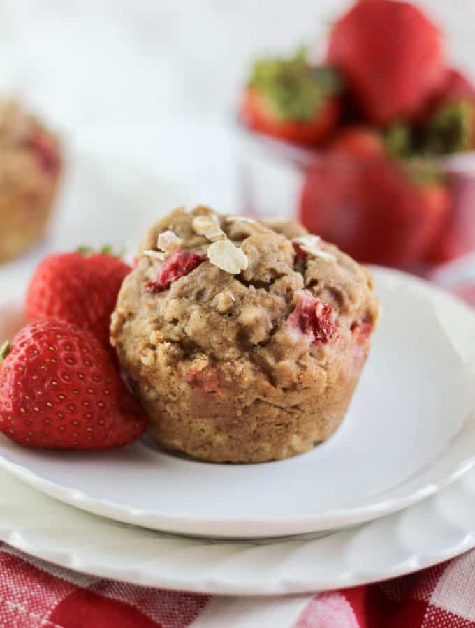A muffin and strawberries on a plate