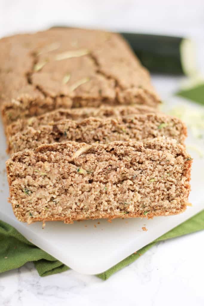 a loaf of Zucchini Oat Bread sliced, with one piece close up