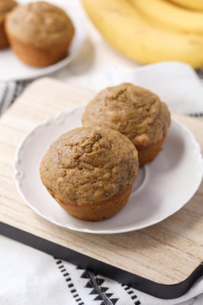 a plate with two banana nut oat muffins, on a tray
