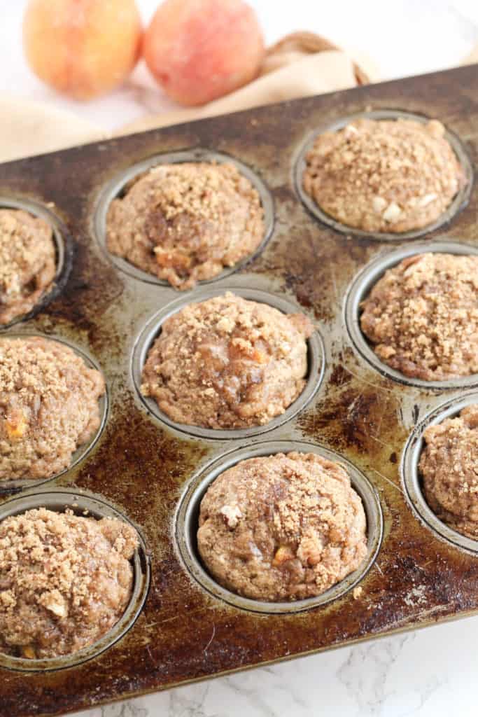 A muffin pan filled with Peach Pecan Oat Muffins