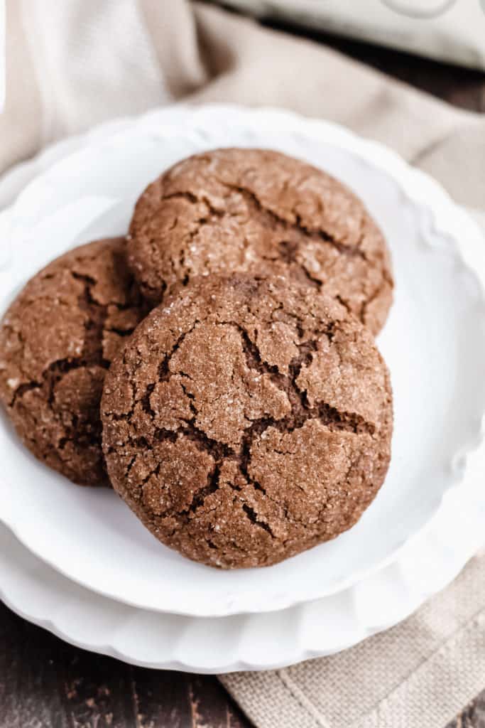 Two plates with three molasses cookies, close up.