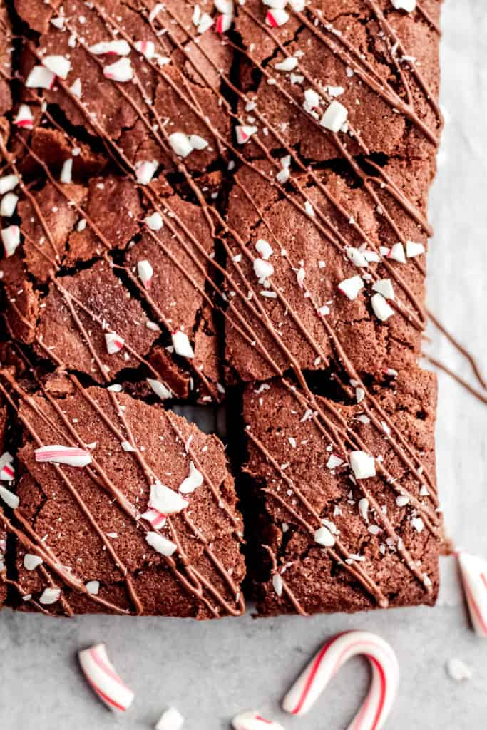 Peppermint Brownies up close, with chocolate drizzle and crushed candy canes sprinkled on top
