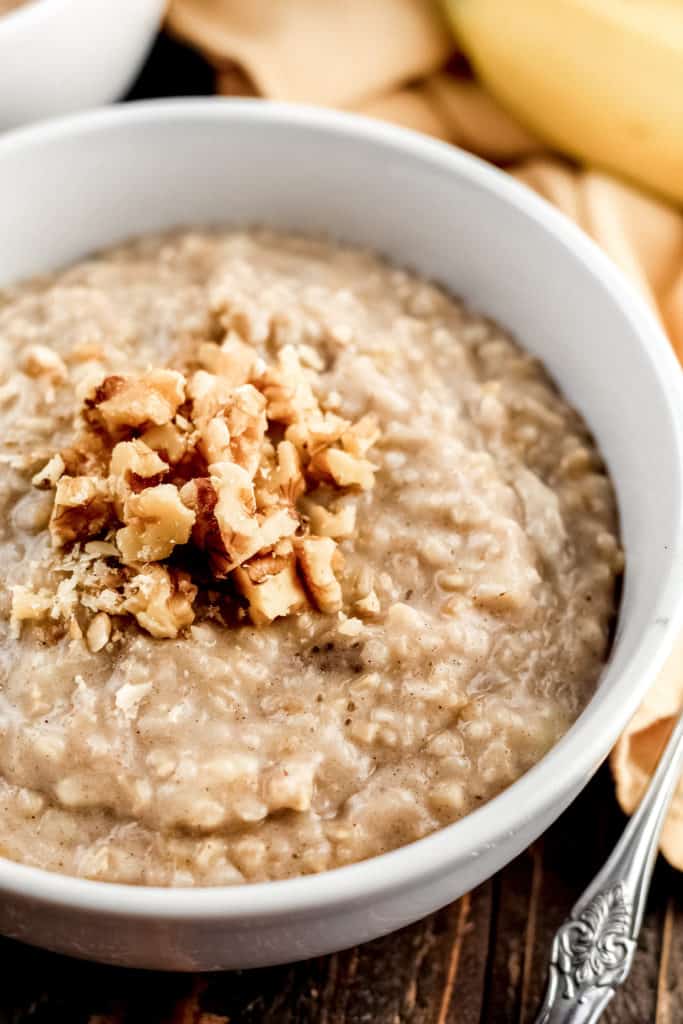 Close up view of a bowl of Banana Steel Cut Oats with walnuts sprinkled on top