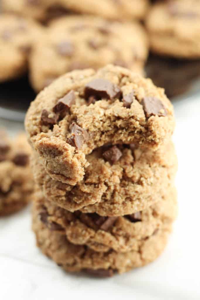 A stack of Grain-free Chocolate Chip Cookies close up, with a bite taken out of the top cookie