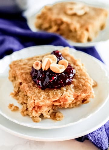 A piece oatmeal on a plate with jelly and peanuts