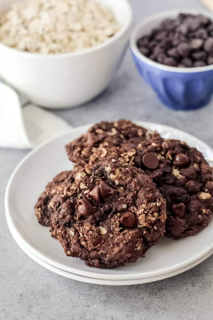 Four double chocolate oatmeal cookies on a plate.