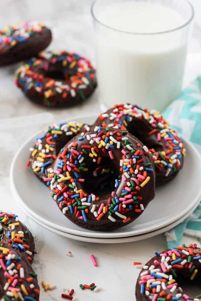 3 chocolate donuts on a plate.