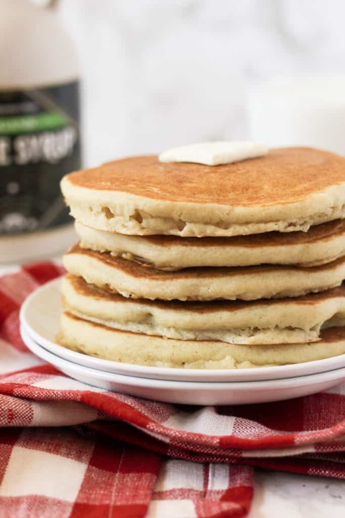 Tall stack of pancakes on a plate.