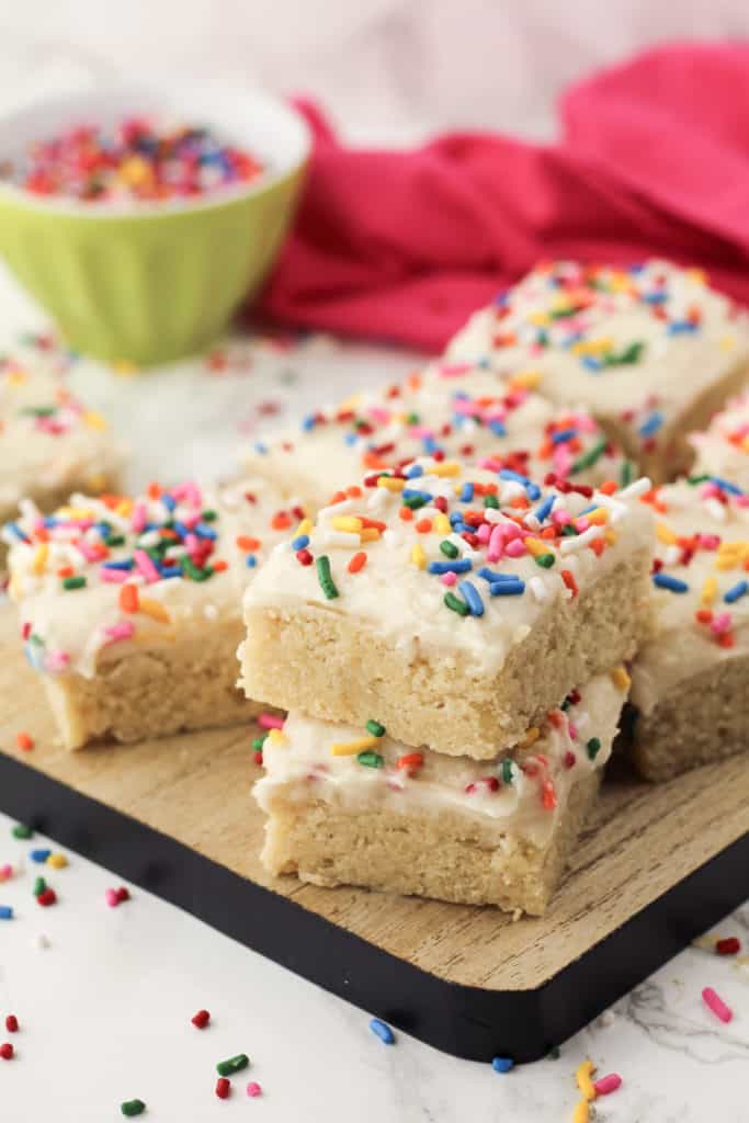 Bars with frosting and sprinkles on a tray.