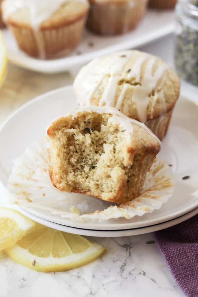 A muffin on a plate with a bite taken out of it