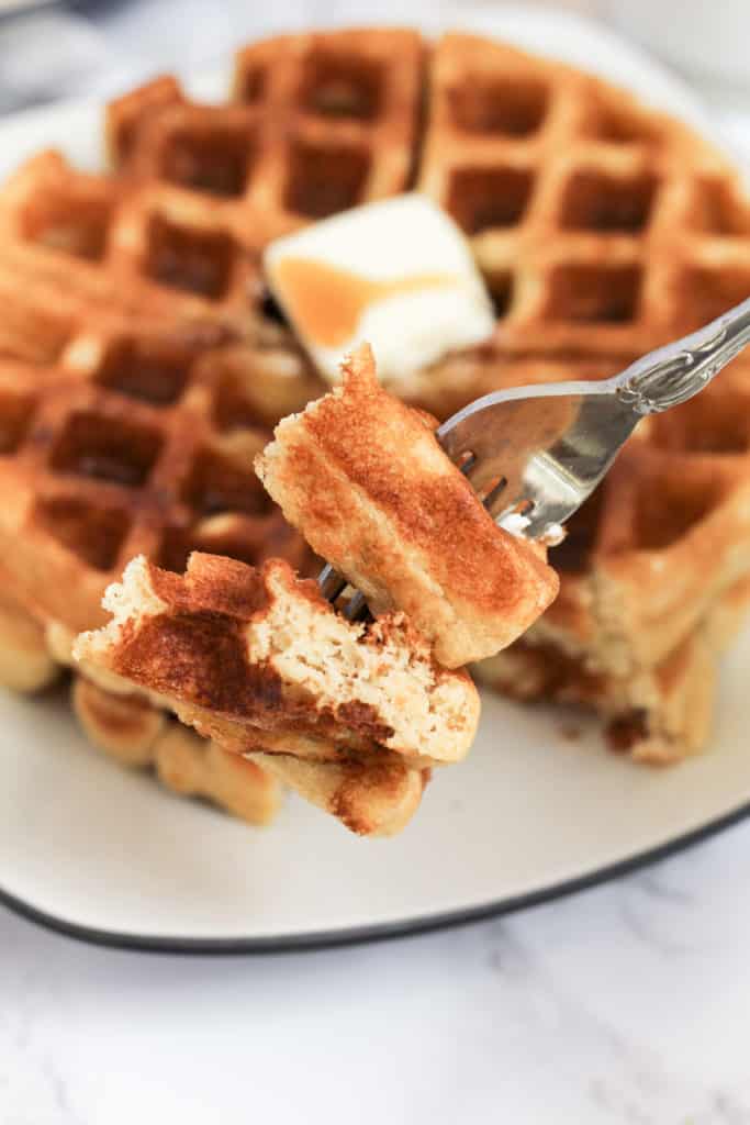 Close up picture of two pieces of waffle on a fork.