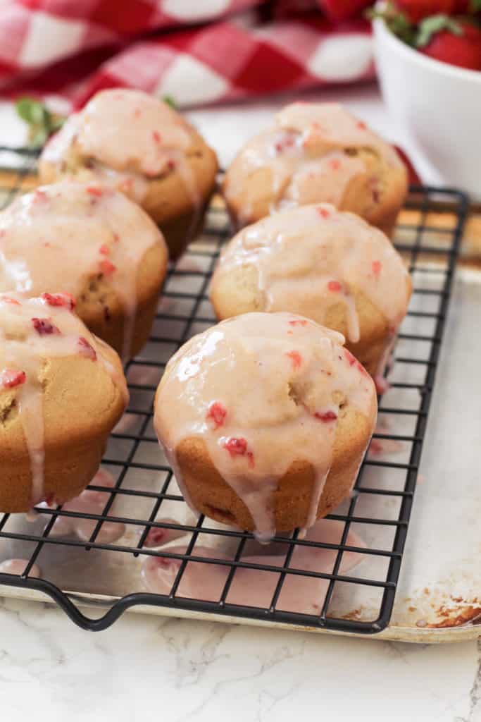 Strawberry muffins getting glazed. 