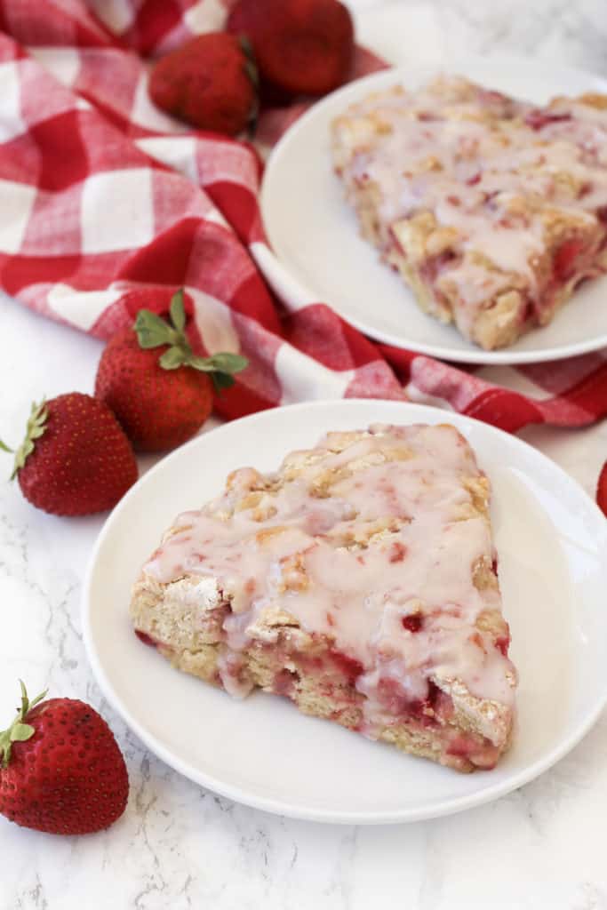 Two strawberry scones on two plates.