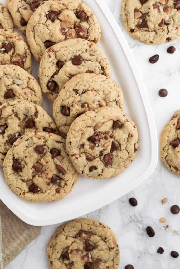 Cookies on a tray with chocolate chips and coffee beans scattered around.