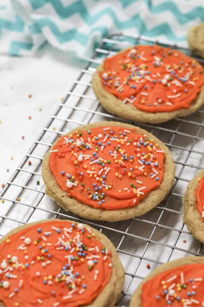 Orange frosted cookie with sprinkles.