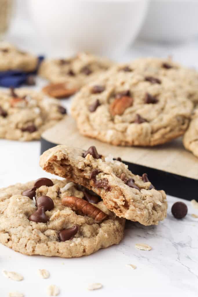 Close up of two cookies, one with a bite taken out of it to see a melty chocolate chip inside.