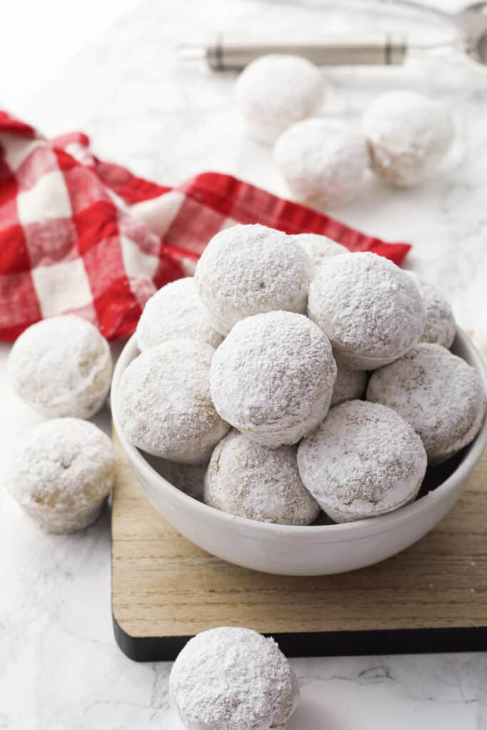 Bowl of Donut Holes with a red plain towel behind.